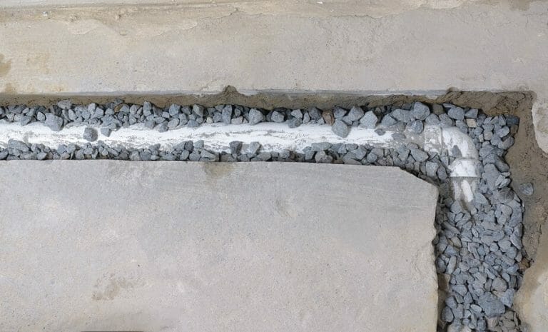 unfinished french drain partially covered with drainage rocks