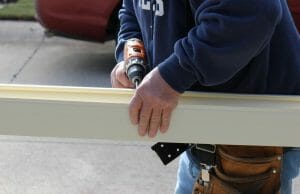 man drilling metal railing