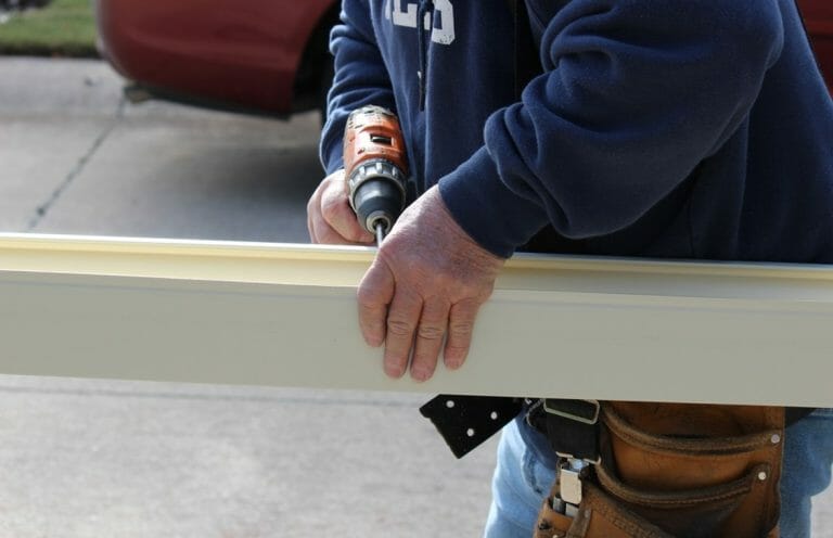 man drilling metal railing