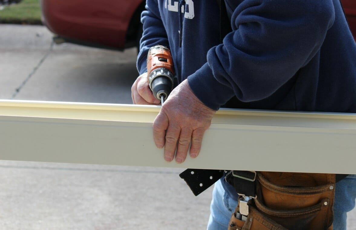 man drilling metal railing