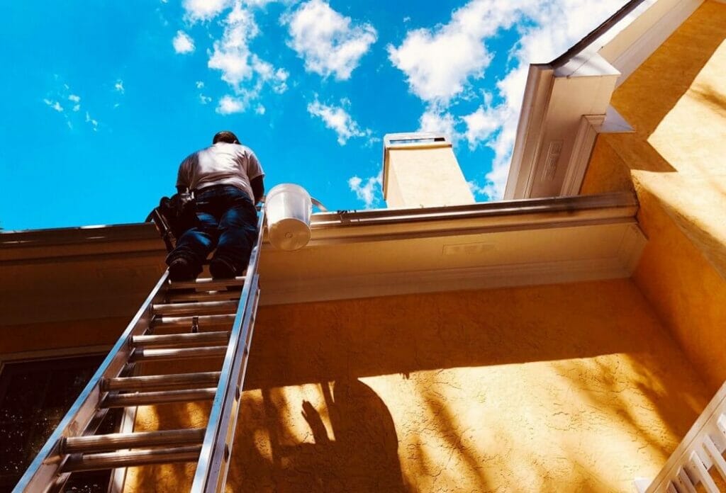 man cleaning gutters